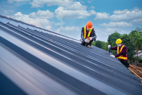 crew installing metal roofing for roof replacement and repair company