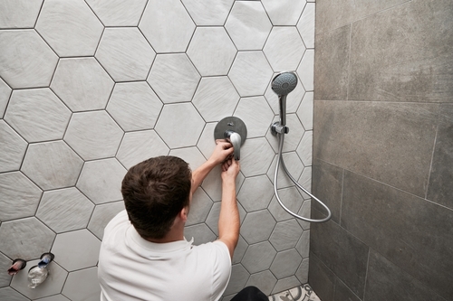 Man installing plumbing on a bathroom remodeling project